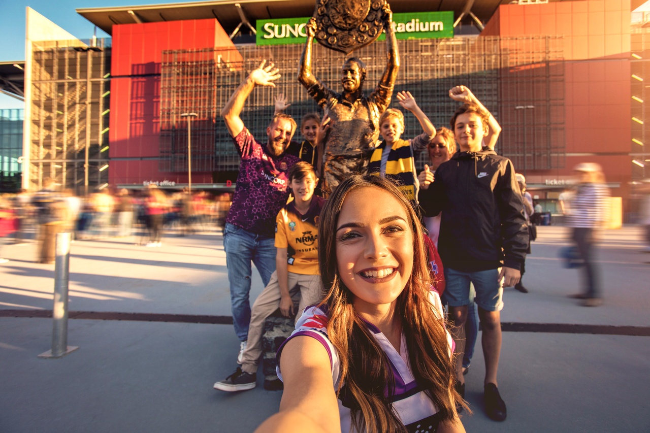 Family taking a selfie with Wally Lewis Statue at Suncorp Stadium 