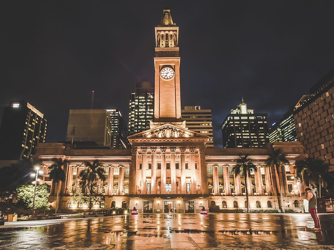 Brisbane City Hall lit up in white lights against a night sky