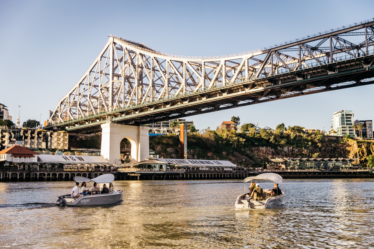 People in a GoBoat on the Brisbane River going under the Story Bridge 