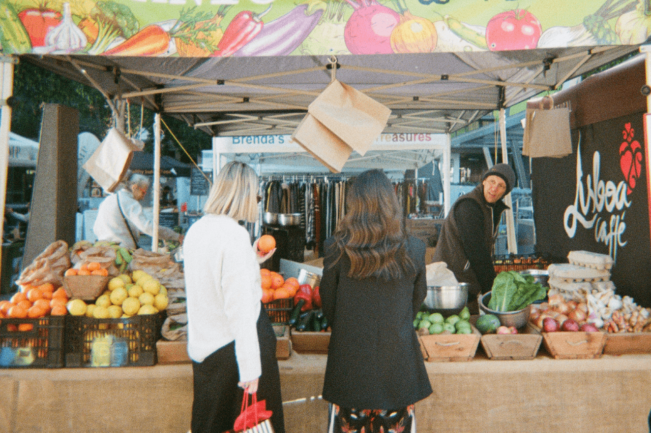 Friends ordering at a fresh produce stall at Brisbane City Markets