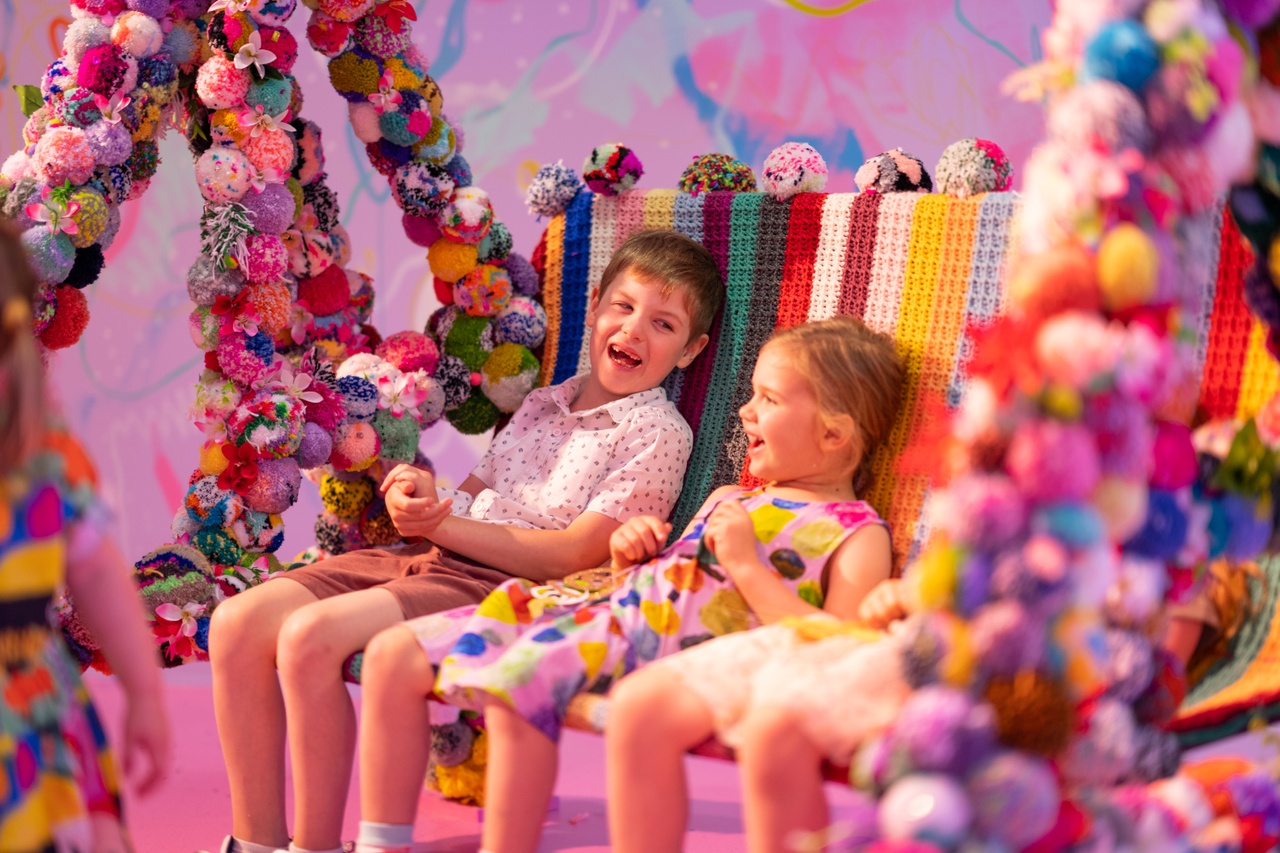 Kids on a swing with balloons in the Museum of Brisbane