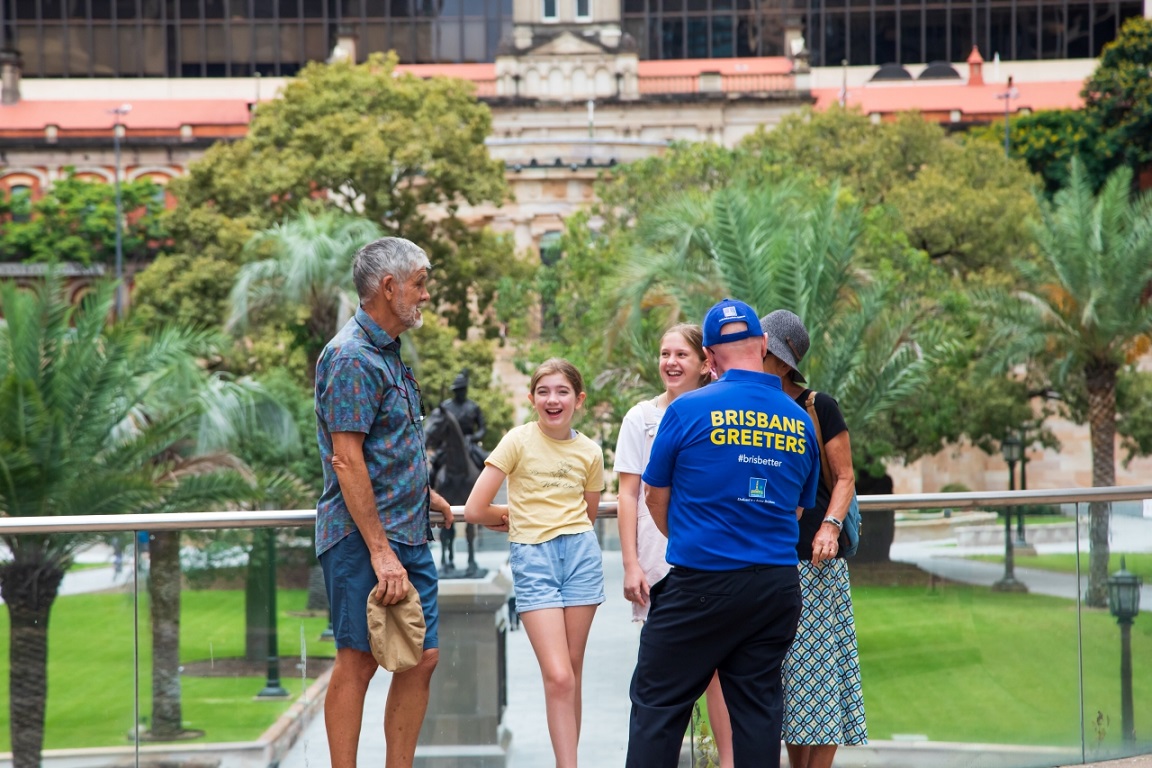 Brisbane Greeter in blue talking to a group at Post Office Square.