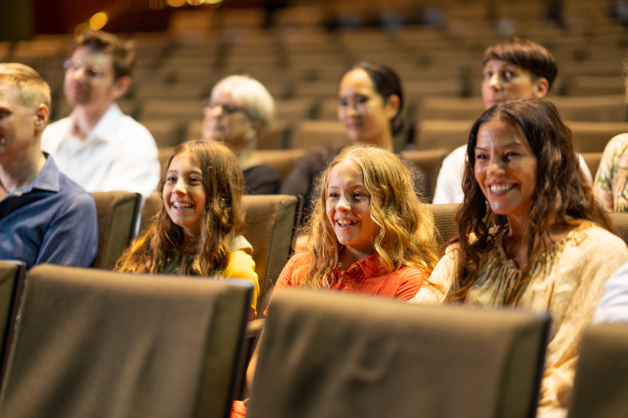 A close up of people sitting in a theatre.