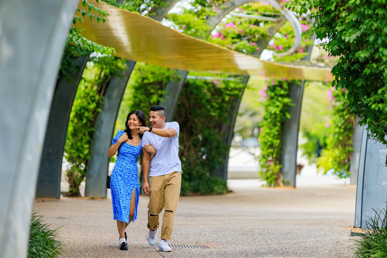 Man pointing at something while the couple walks through the Arbour Walkway