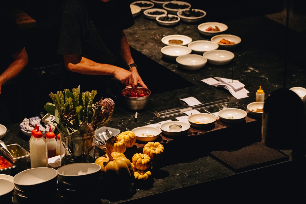 Chef preparing food with a dark background at Agnes, Fortitude Valley.