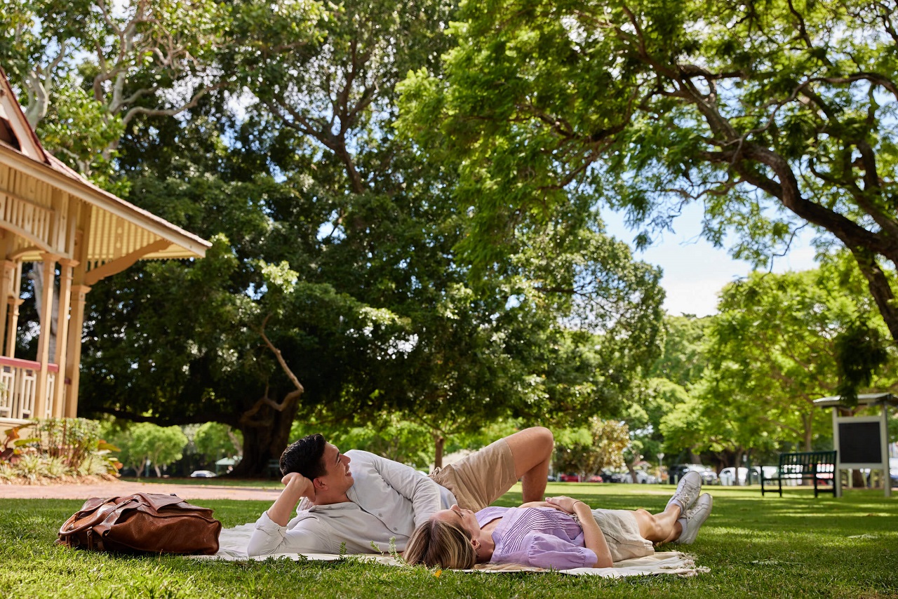 Couple relaxing on a picnic blanket at New Farm Park