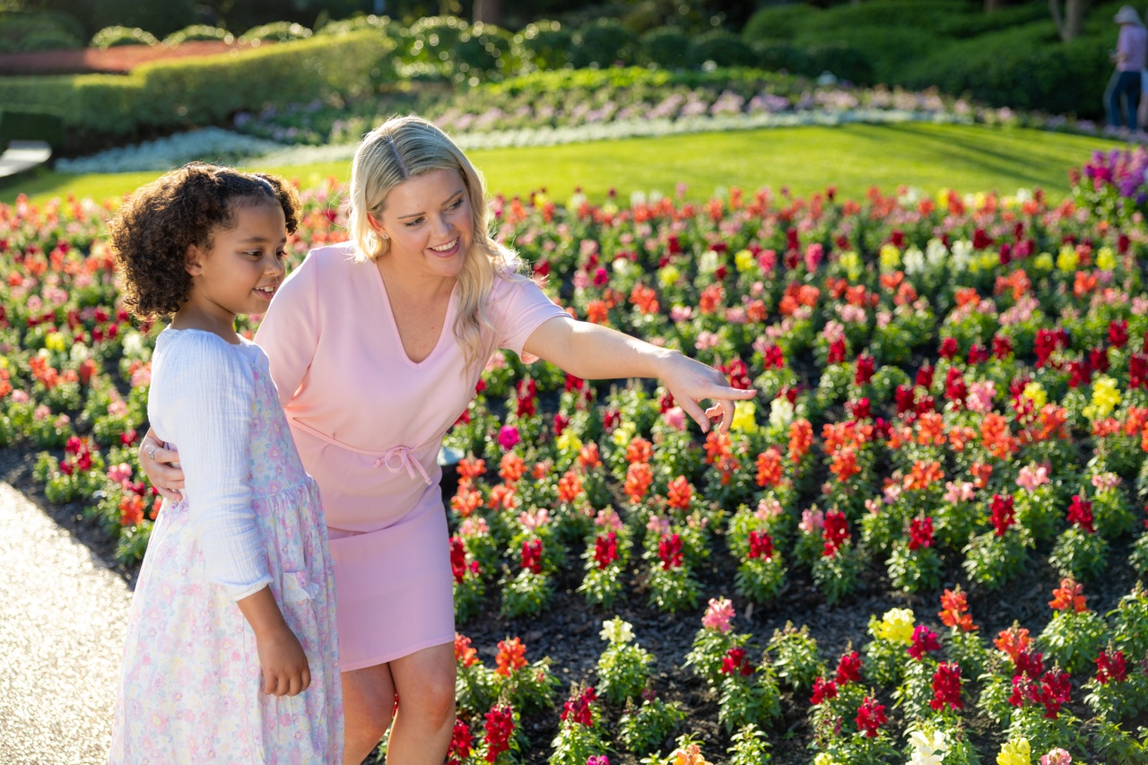A mother pointing at the flowers with her daughter at Roma Street Parkland.