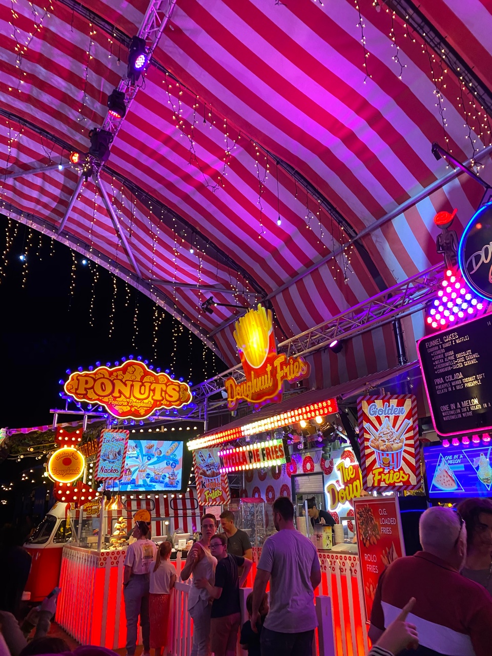 Image of people at an Eat Street dessert stall with fairy lights hanging above them