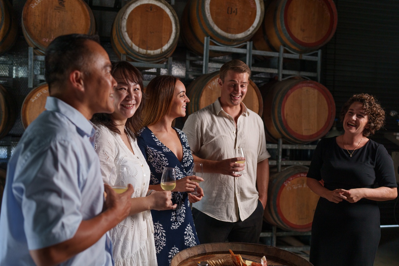A group of people wine tasting with a staff at Ocean View Estates.