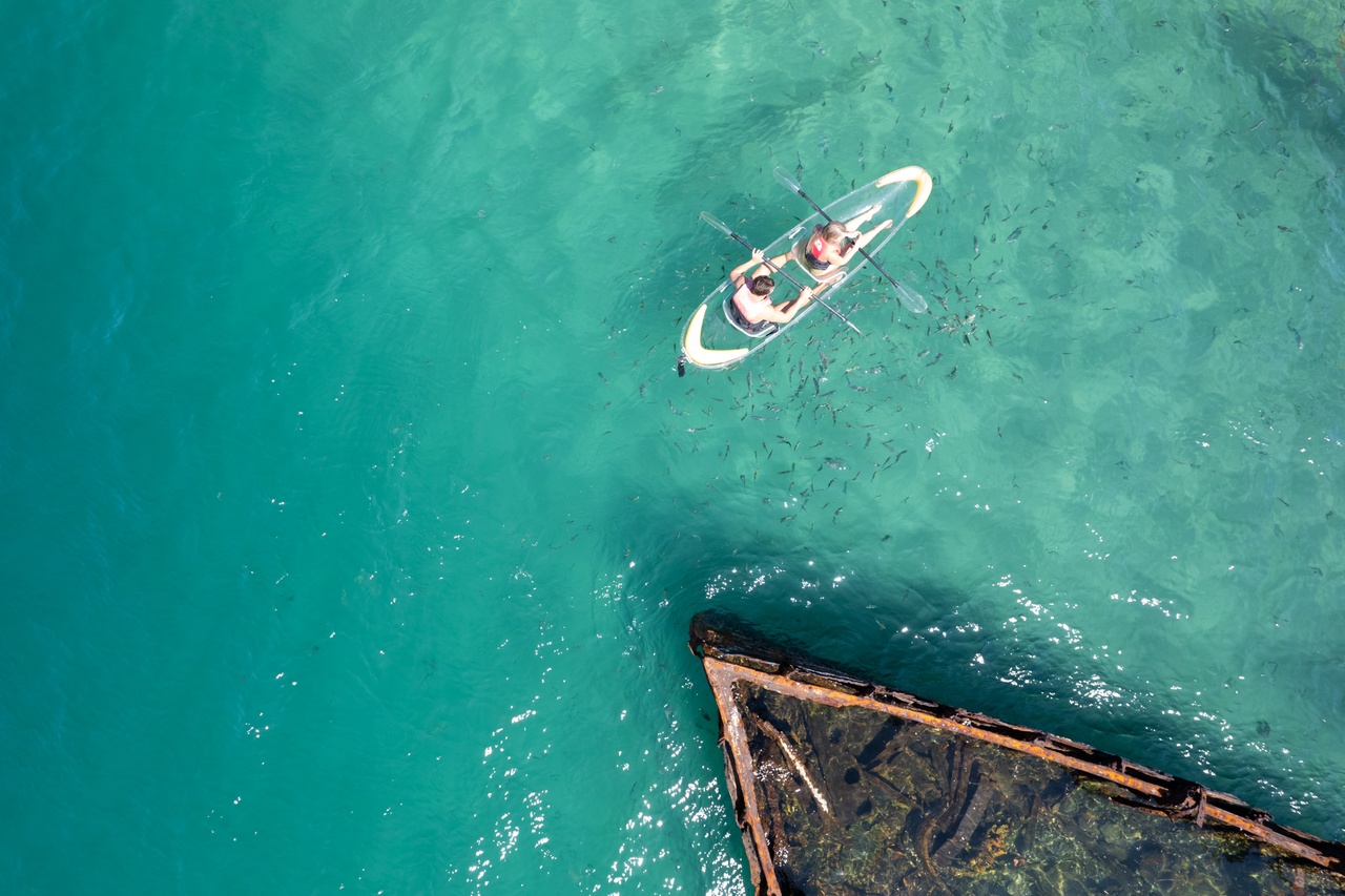 A top view image of a couple kayaking near the shipwreck.