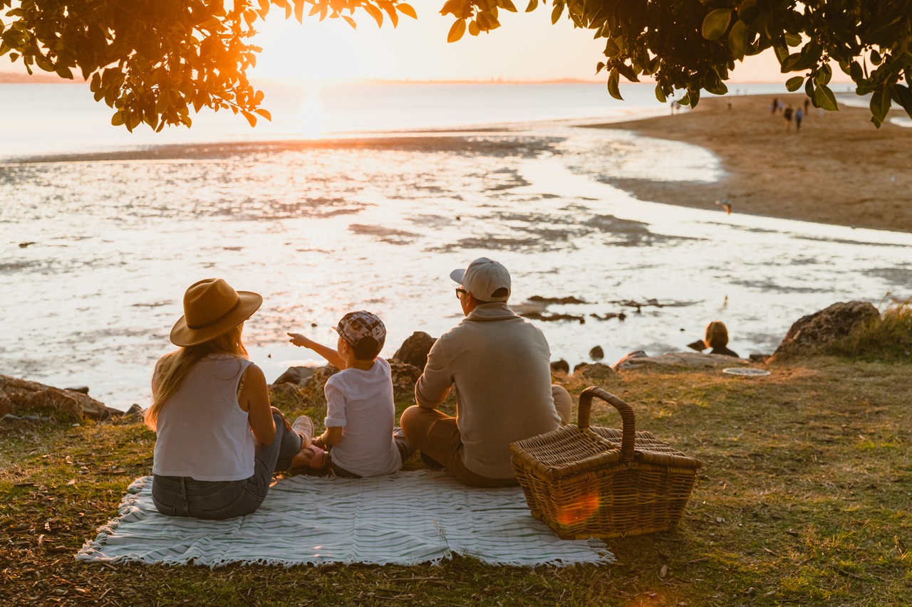 A family of three having picnic by seaside at Wellington Point.
