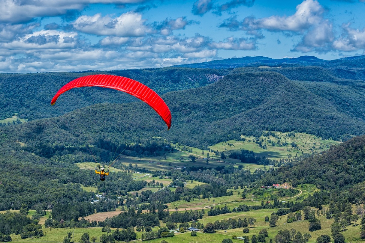 Red paraglider soars over the Scenic Rim.