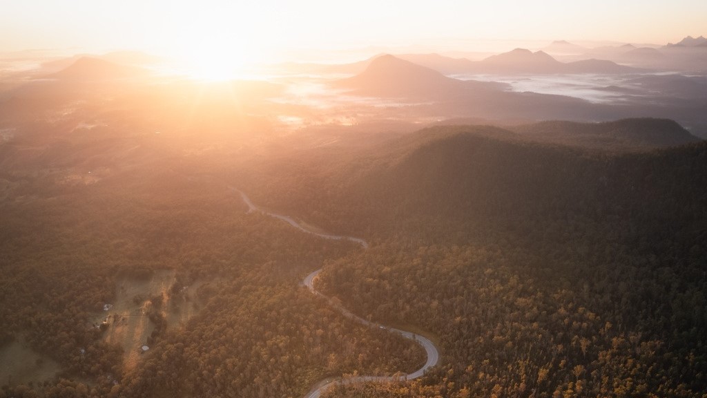 An aerial image of the scenic rim, with a road that snakes around forest areas.