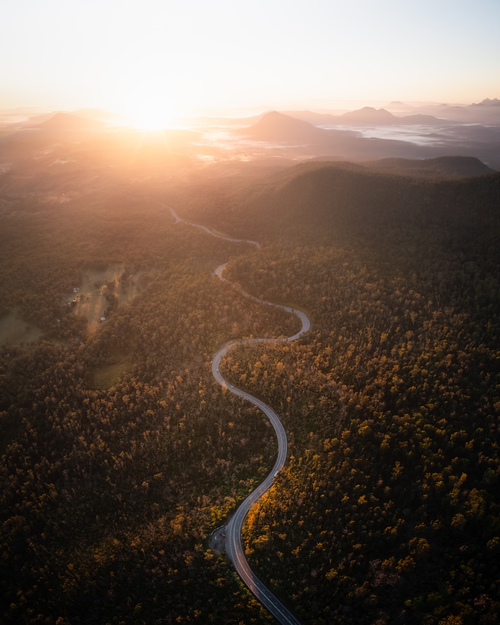 An aerial image of the scenic rim, with a road that snakes around forest areas.