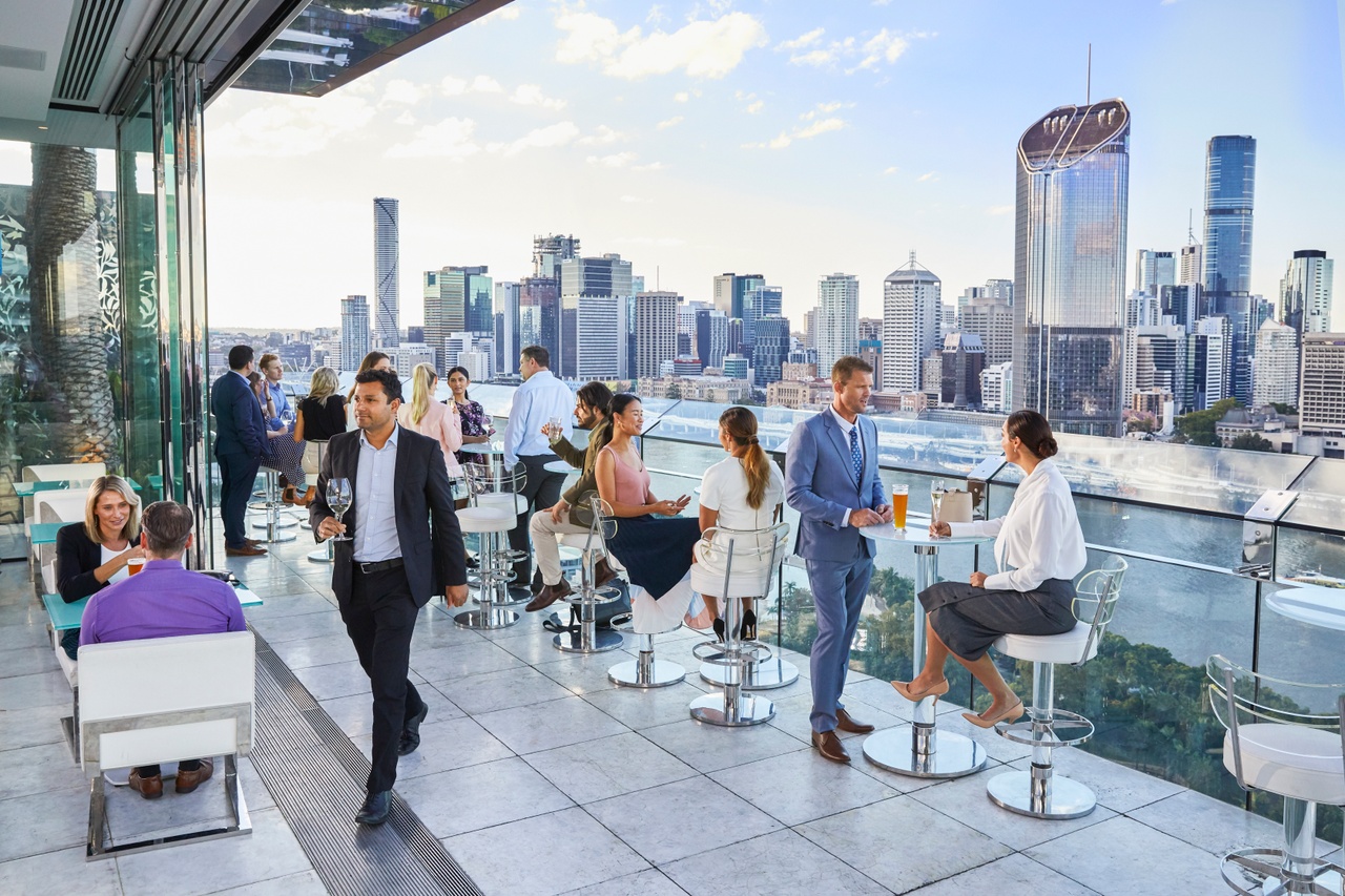 Landscape image of corporate people having drinks at the Emporium Hotel South Bank rooftop bar